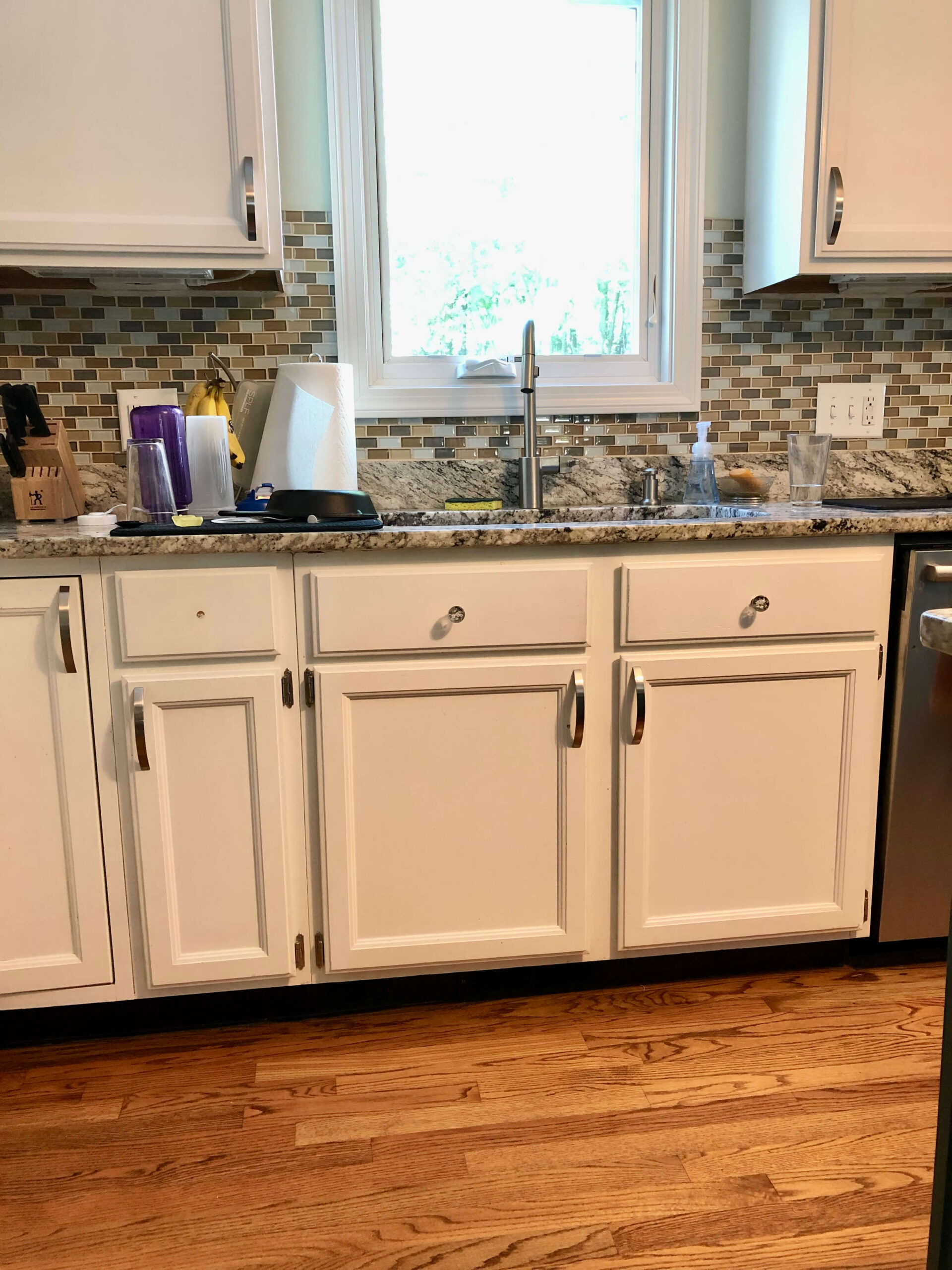 old white kitchen cabinets painted with glass backsplash