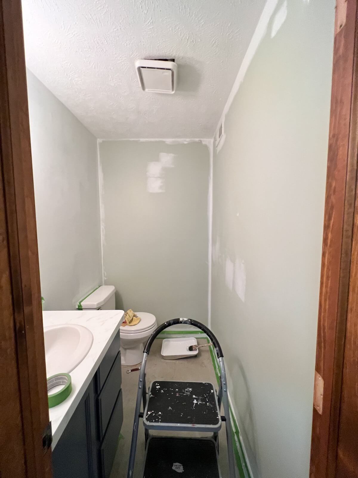 small bathroom with white paint on some parts of the walls.