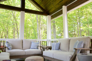 two loveseats with cushions in screened in porch.