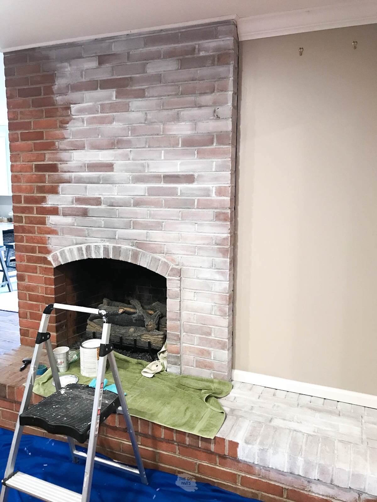first coat of white paint on brick fireplace.