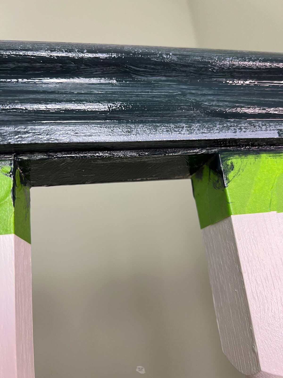 one coat of black paint on a stair railing banister.