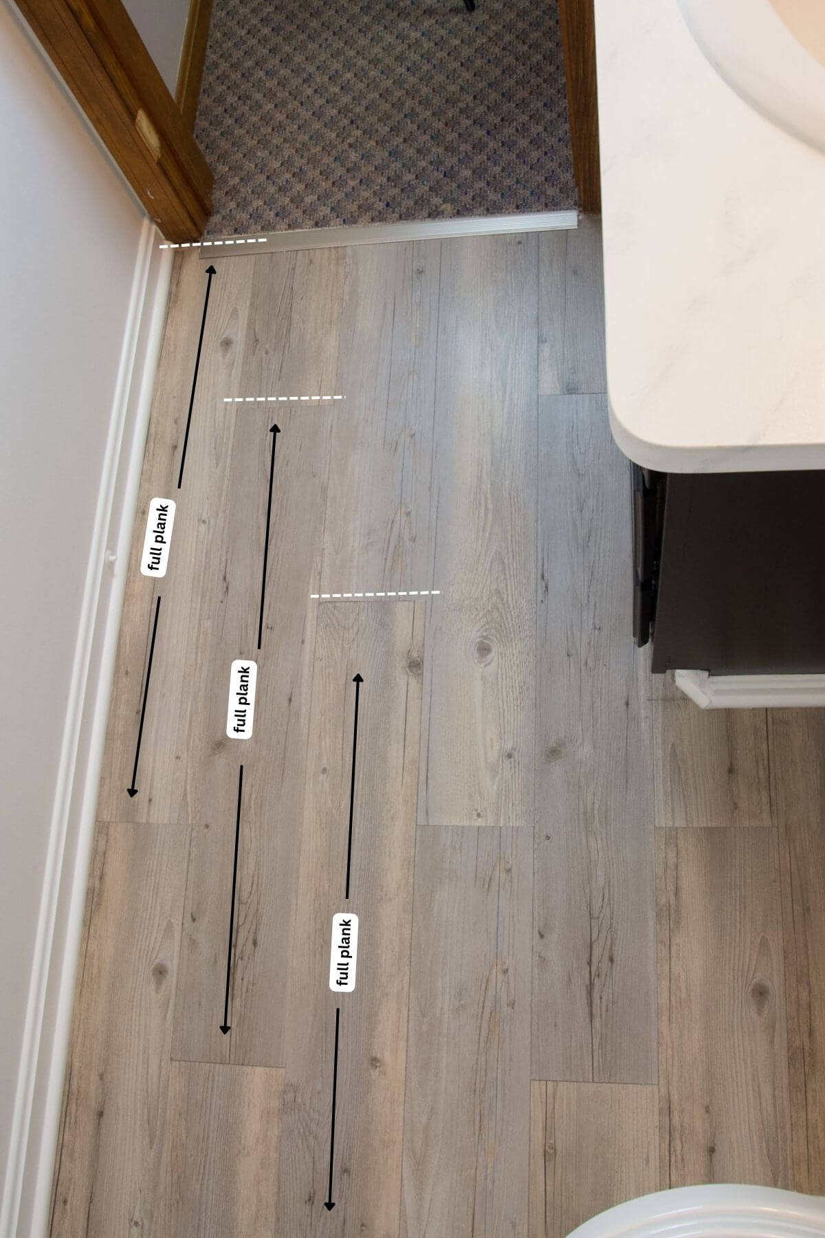 lines showing peel and stick wood tiles on bathroom floor.