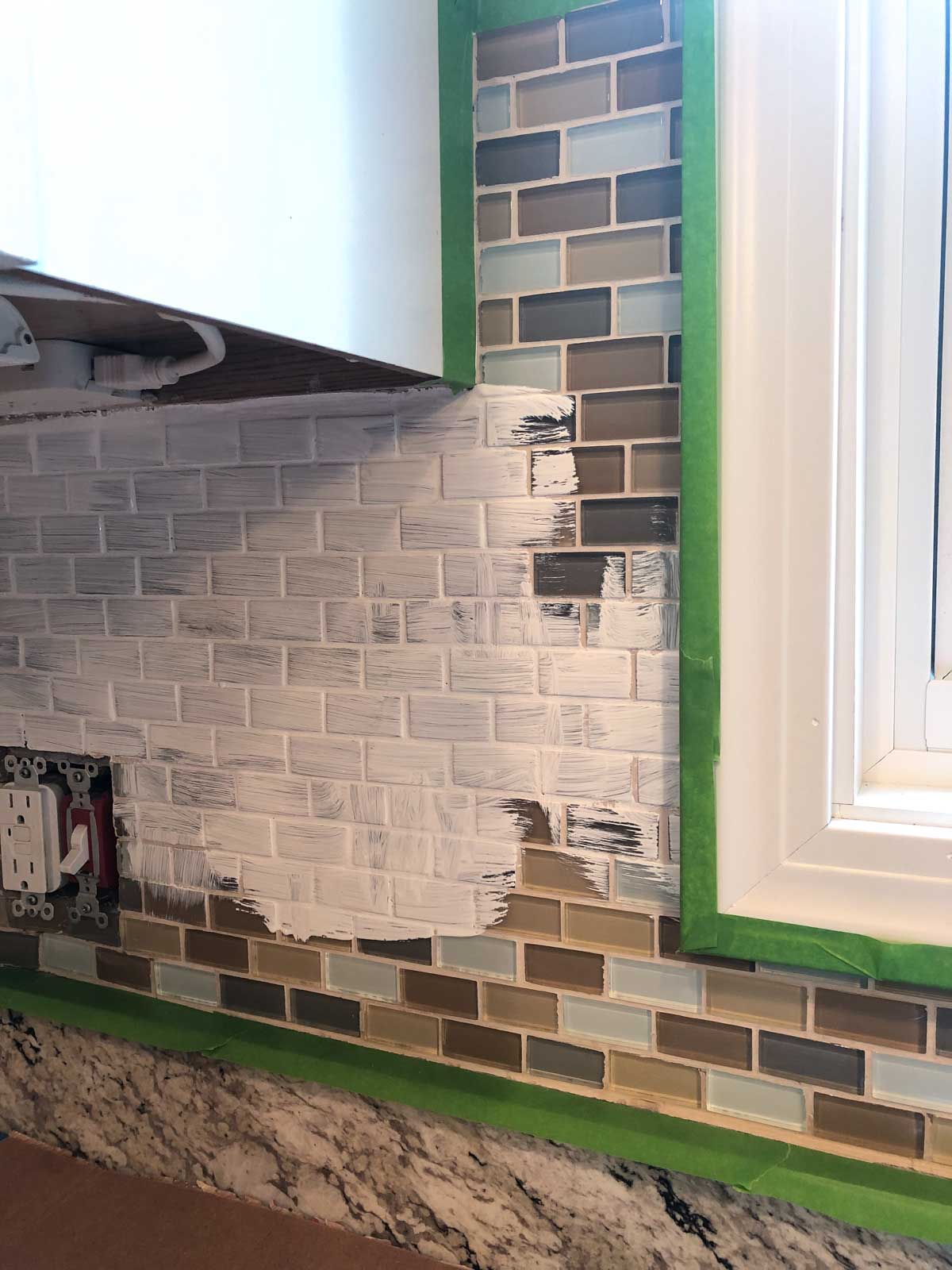 white primer on glass mosaic kitchen backsplash.
