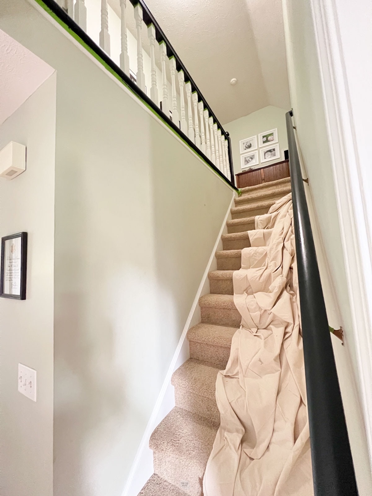 drop cloth on stair railing and handrail painted black and white.