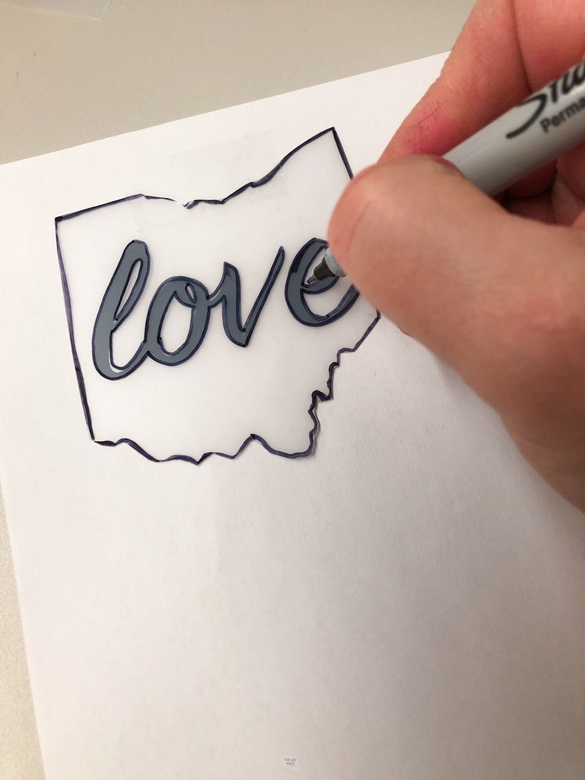 hand tracing Ohio outline on plastic.