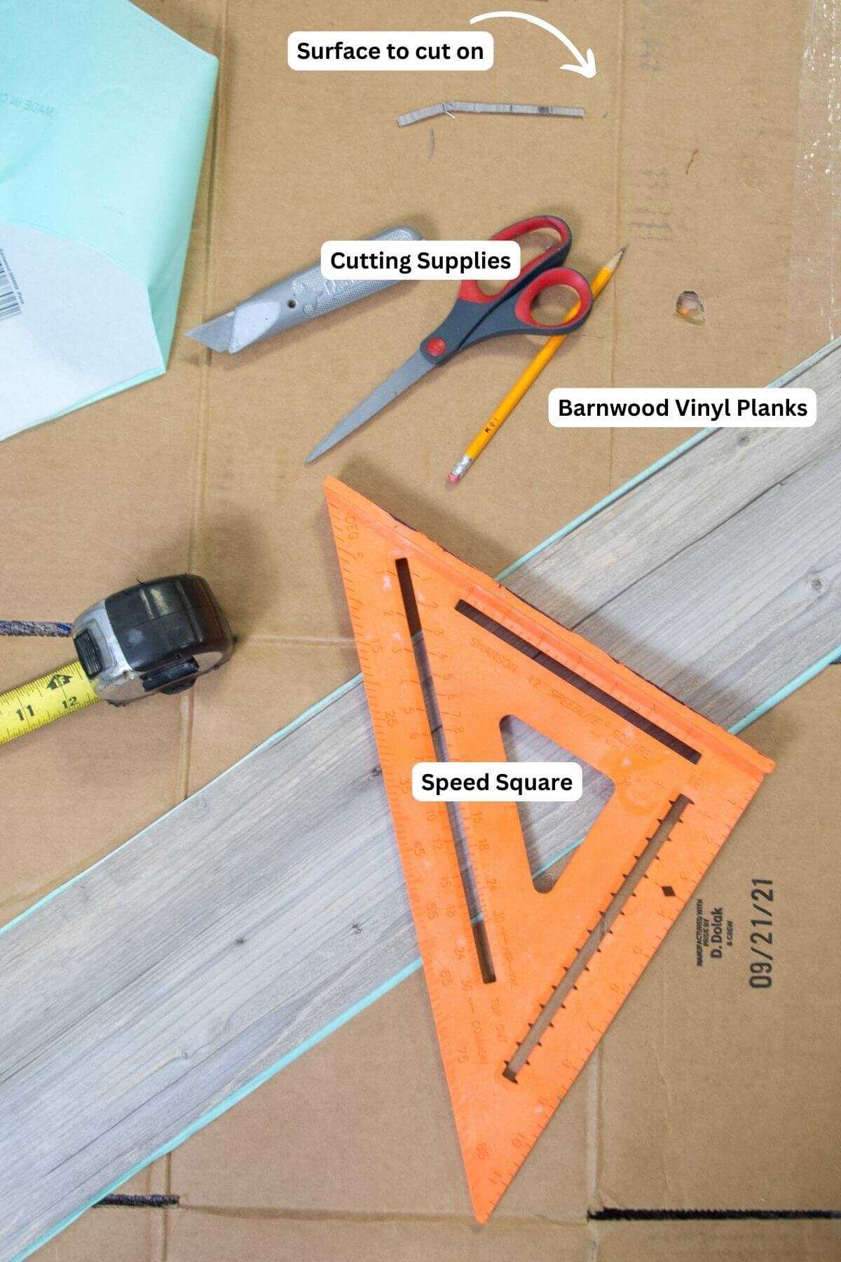 peel and stick flooring installation supplies, utility knife, orange speed square, faux wood plank peel stick tile & tape measurer.