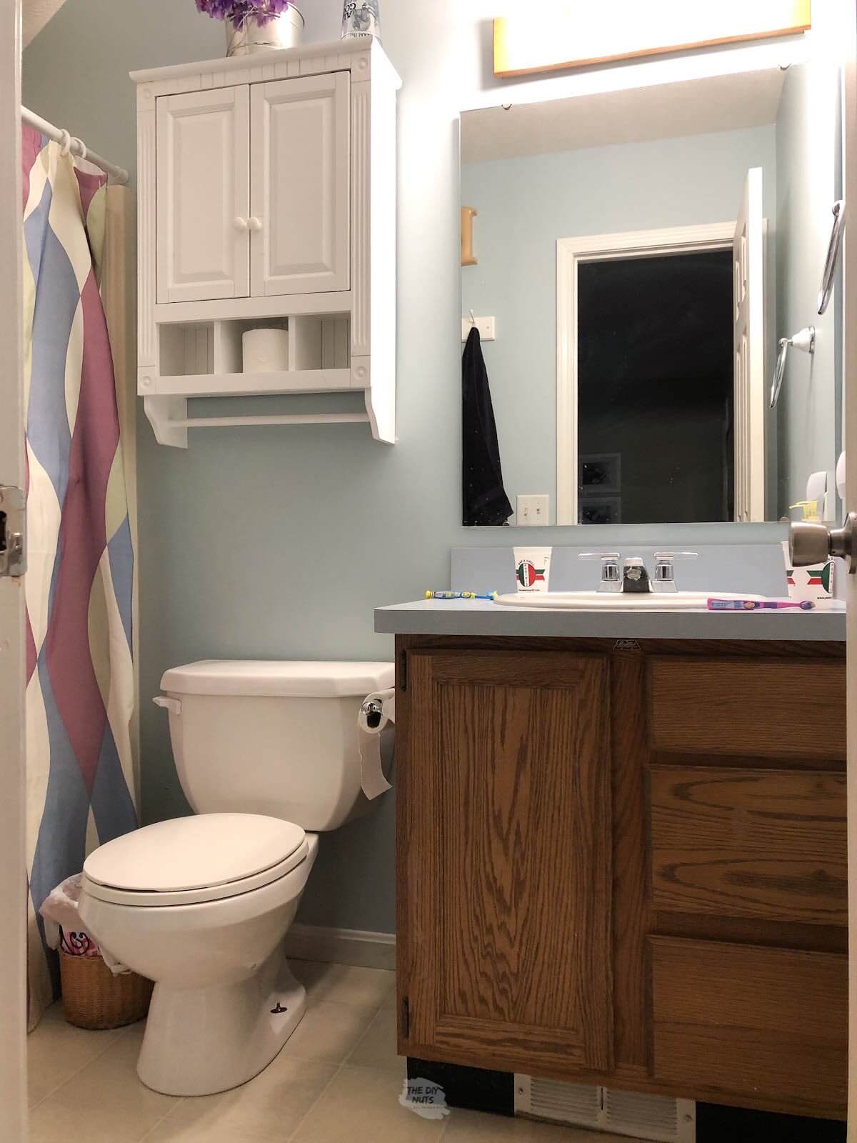 oak bathroom cabinets, white cabinet with mirror and shower curtain.