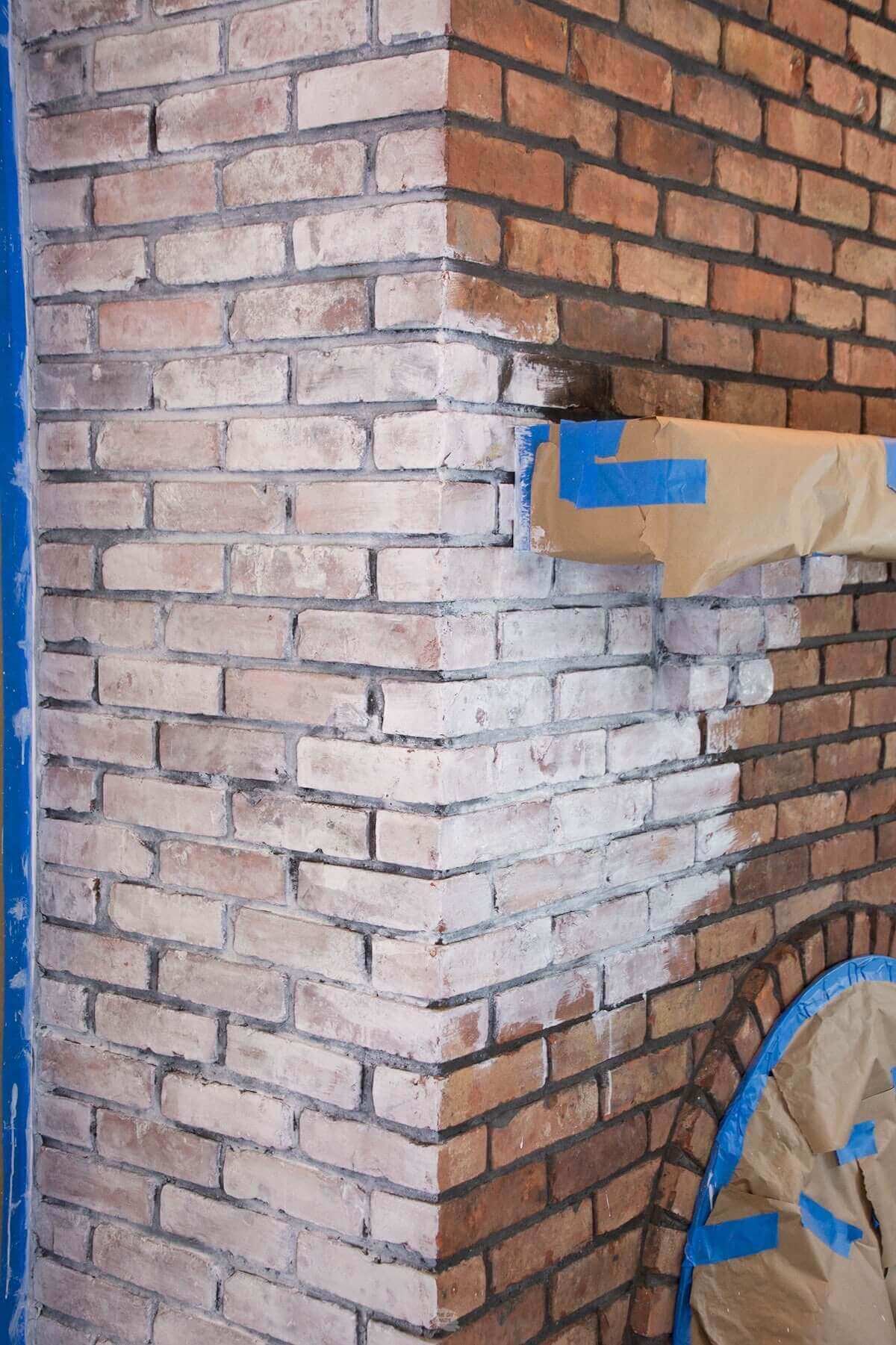 brick fireplace being whitewashed white.