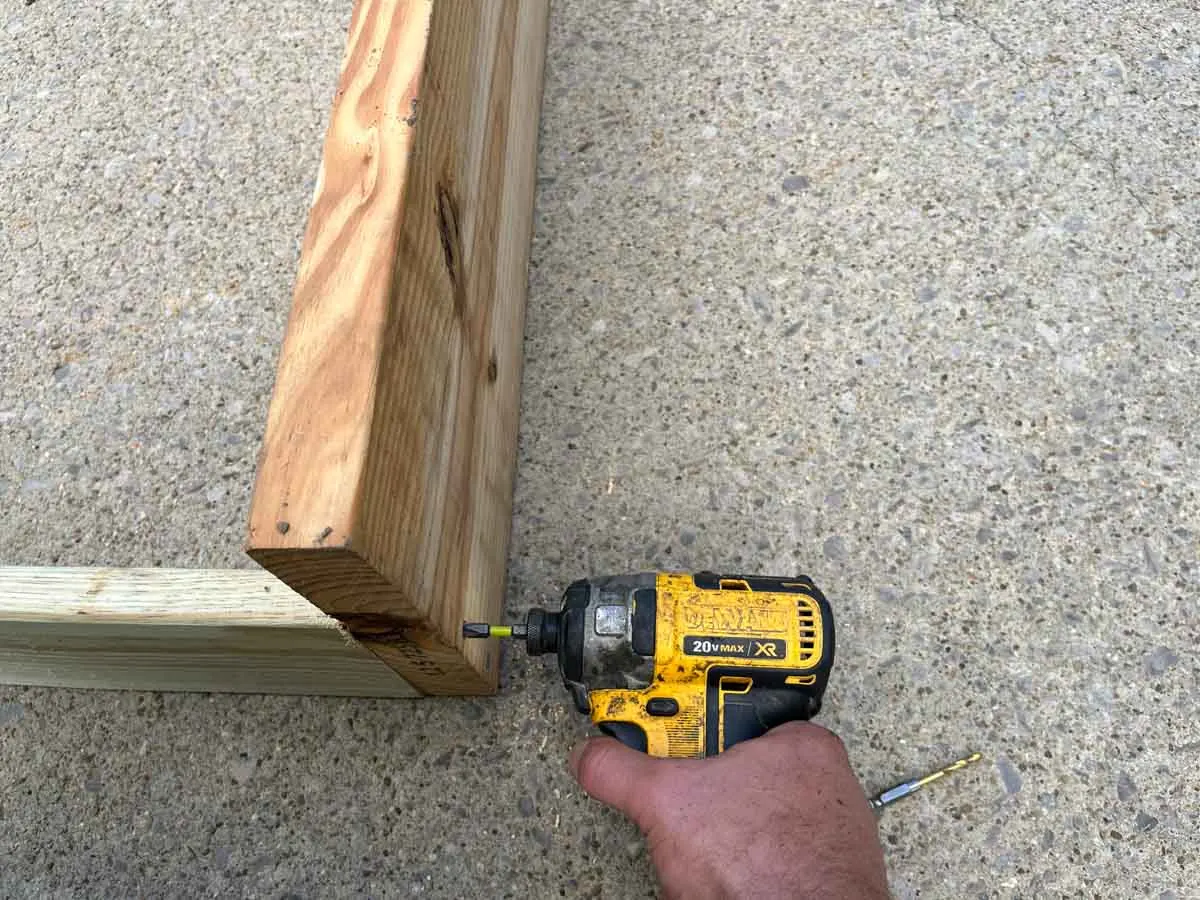 hand using an impact driver to attach wood together.