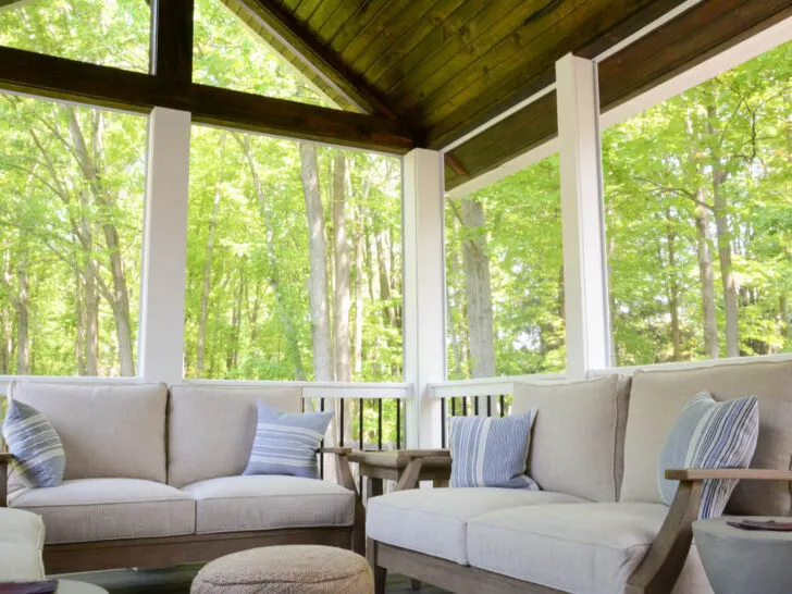 two loveseats with cushions in screened in porch.