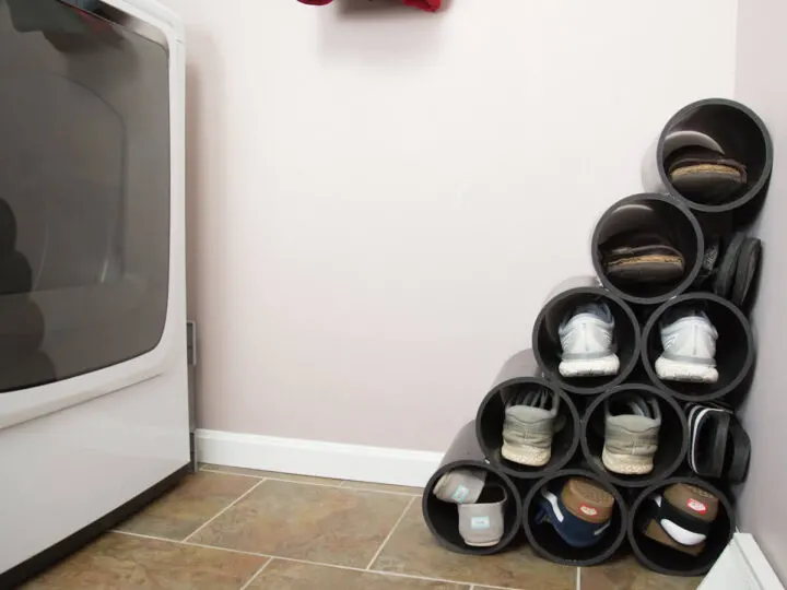 black painted PVC shoe rack in laundry room storing shoes.