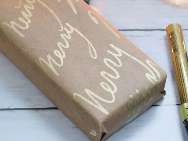 zoomed in gold writing on brown butcher paper wrapped box on shiplap.