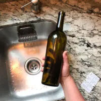 wine bottle in hand with label taken off