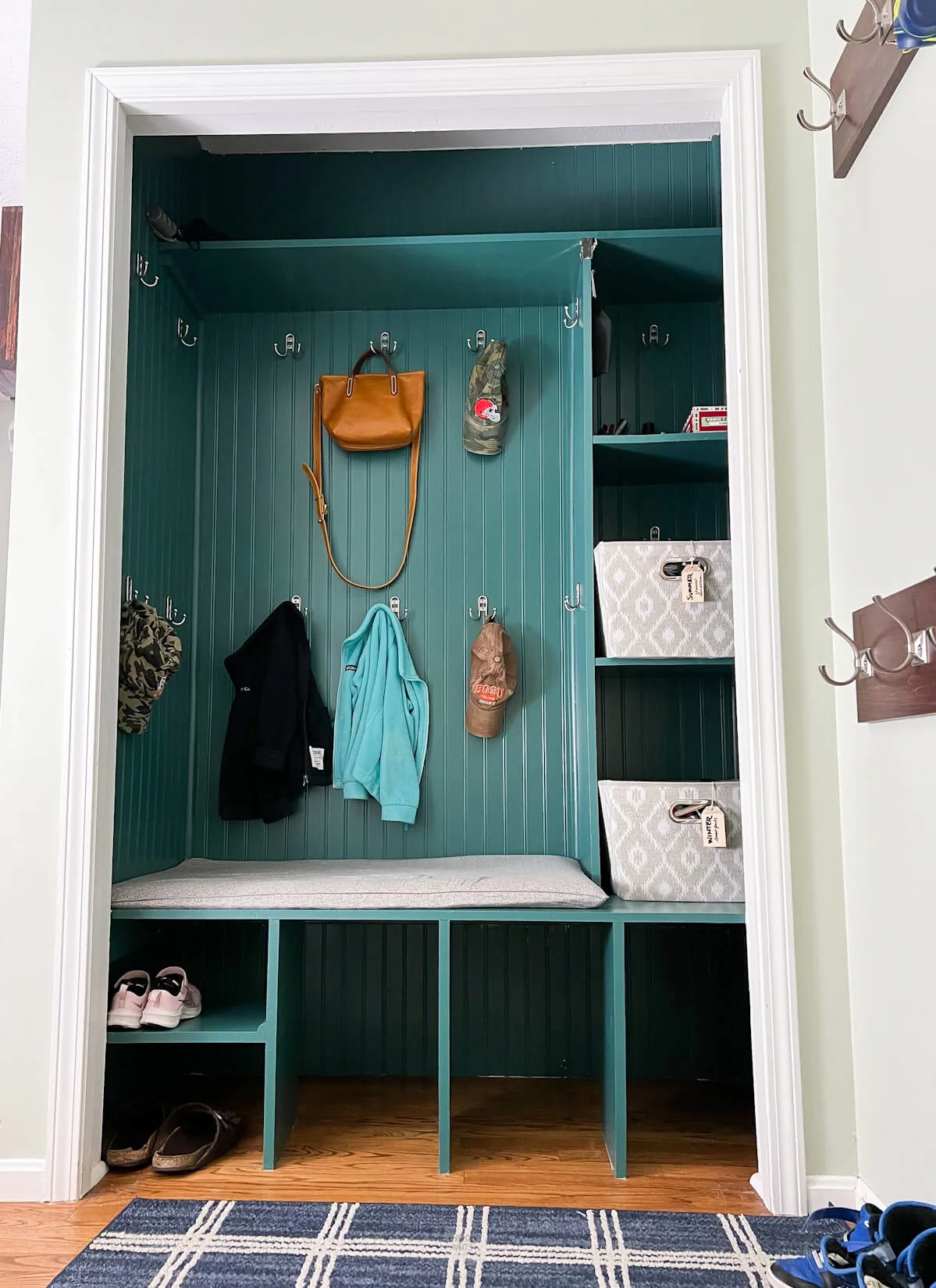 items hanging in finished painted cubby mudroom closet.