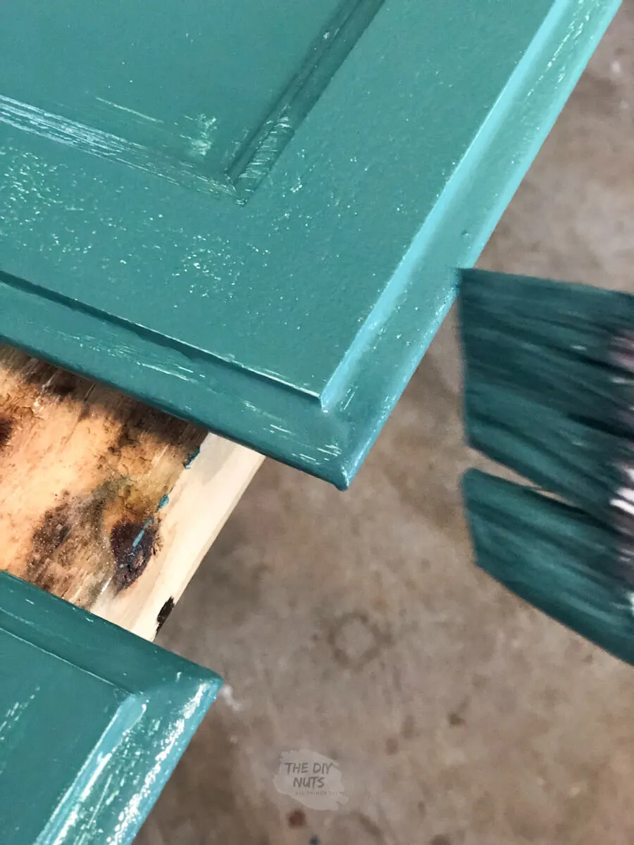 zoomed in corner of cabinet door with SW Rookwood Sash Green paint on brush.
