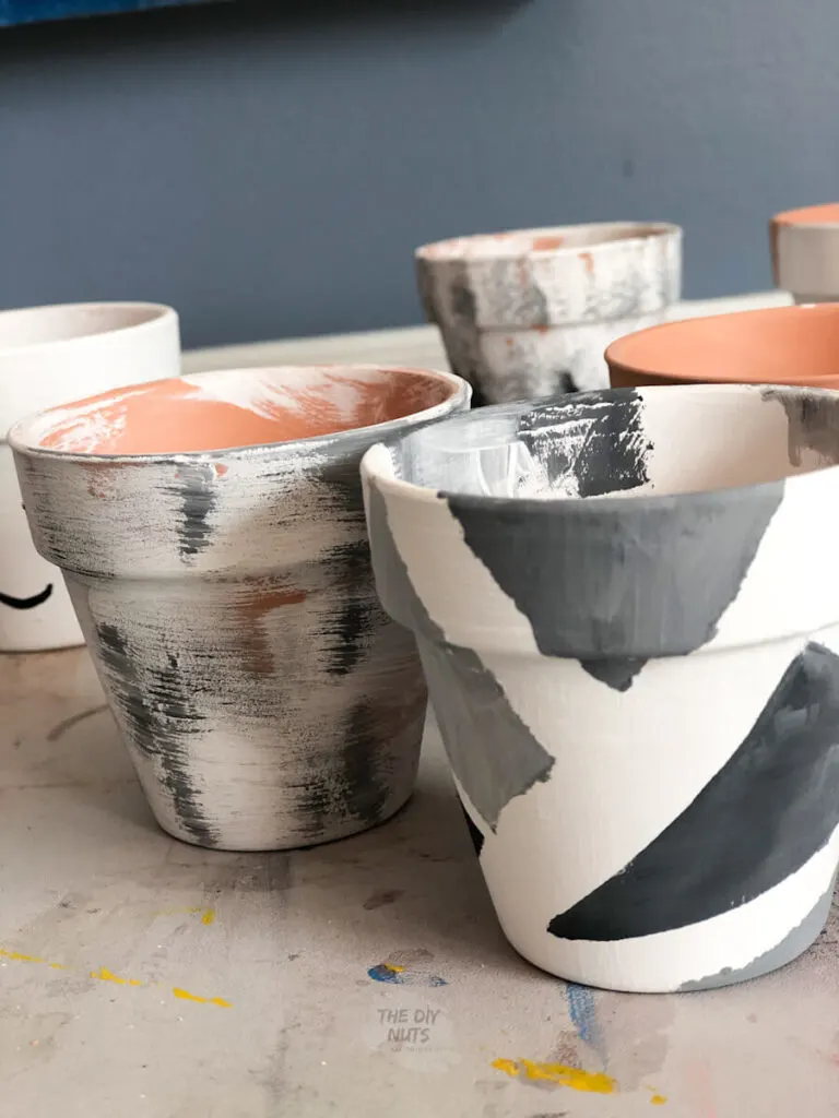painter's tape used to create diy painted flower pot design