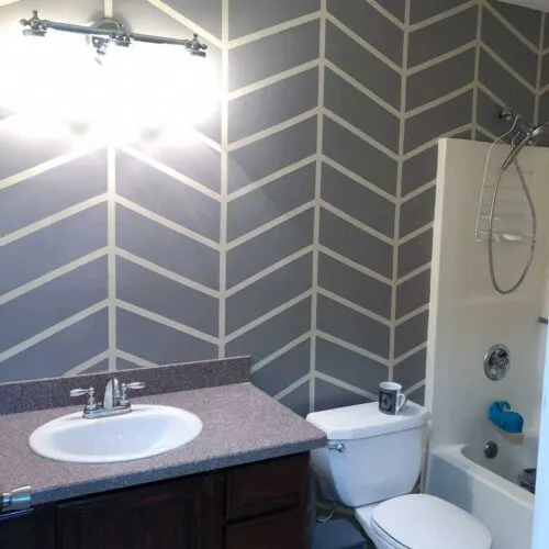 Painted herringbone gray accent wall in bathroom.
