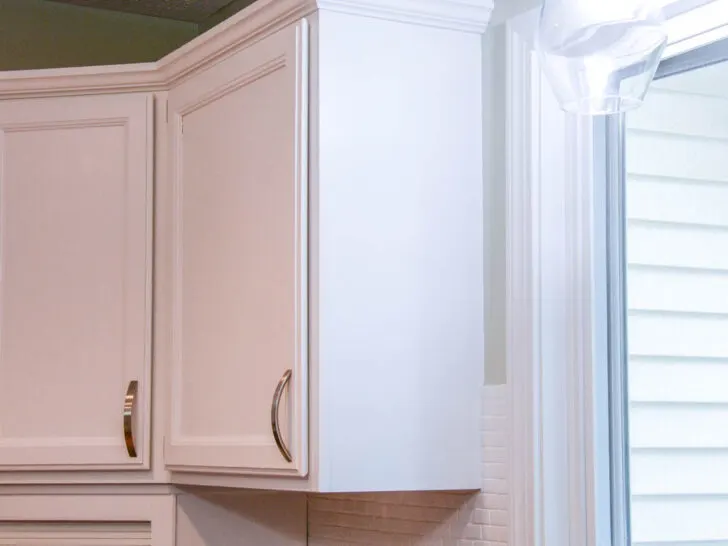 white painted upper kitchen cabinets with brushed nickel handles.