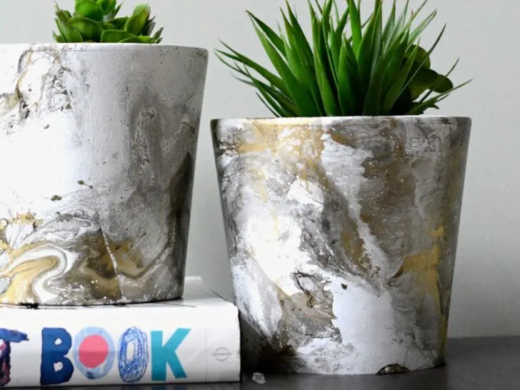 two painted terracotta pots with spray paint for marble effect.