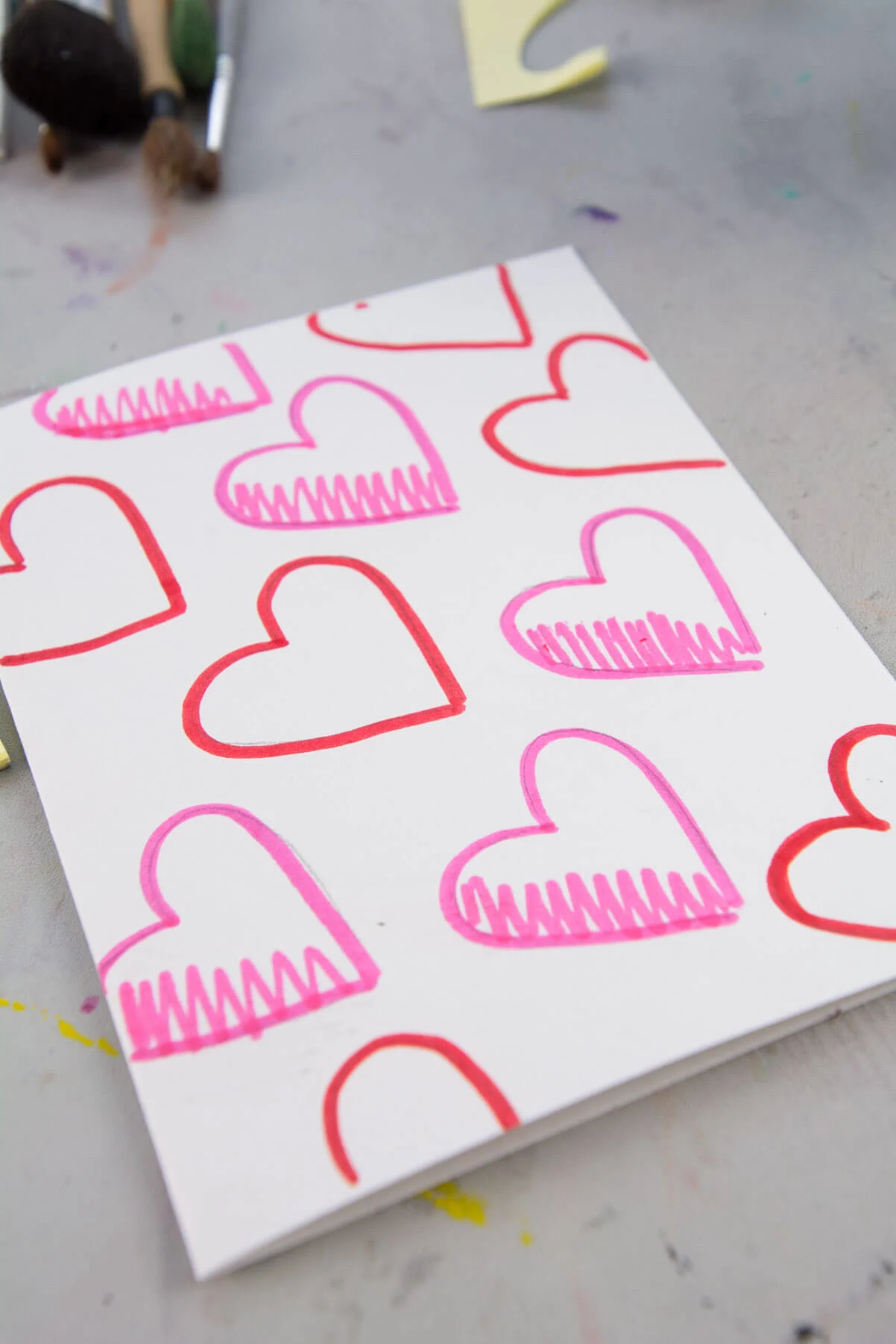 red and pink hearts drawn with marker on white paper.