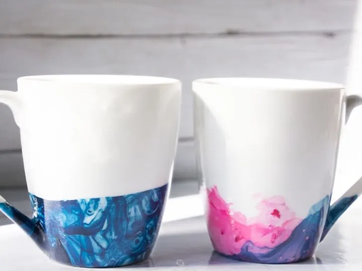 2 nail polish marbled mugs with blue and blue and pink.