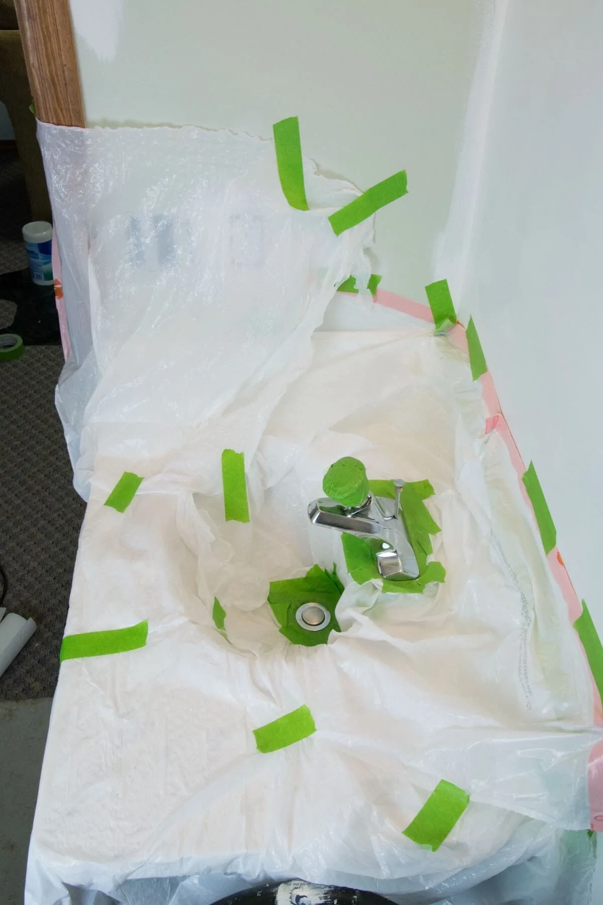 sink with plastic bags and green tape around it.