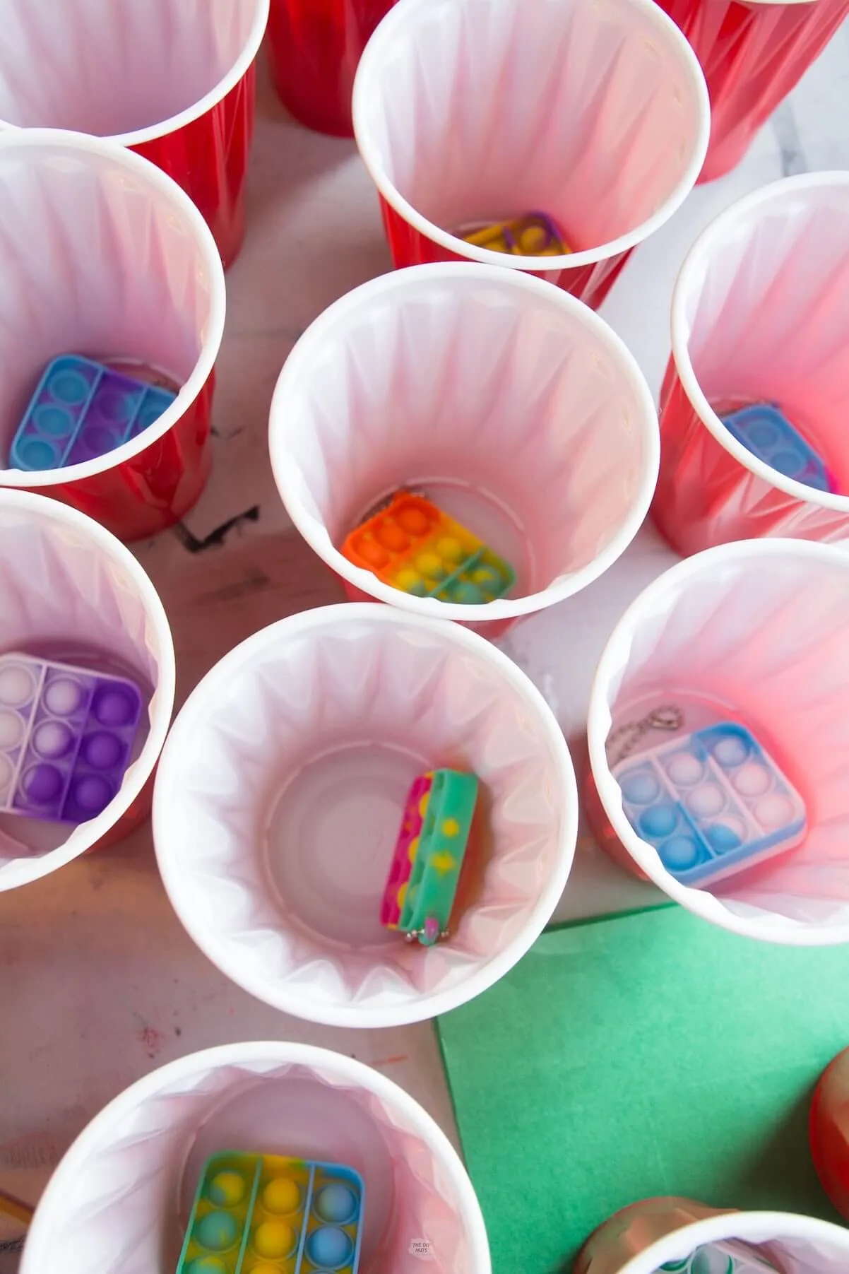 small pop-it keychains in plastic cups.