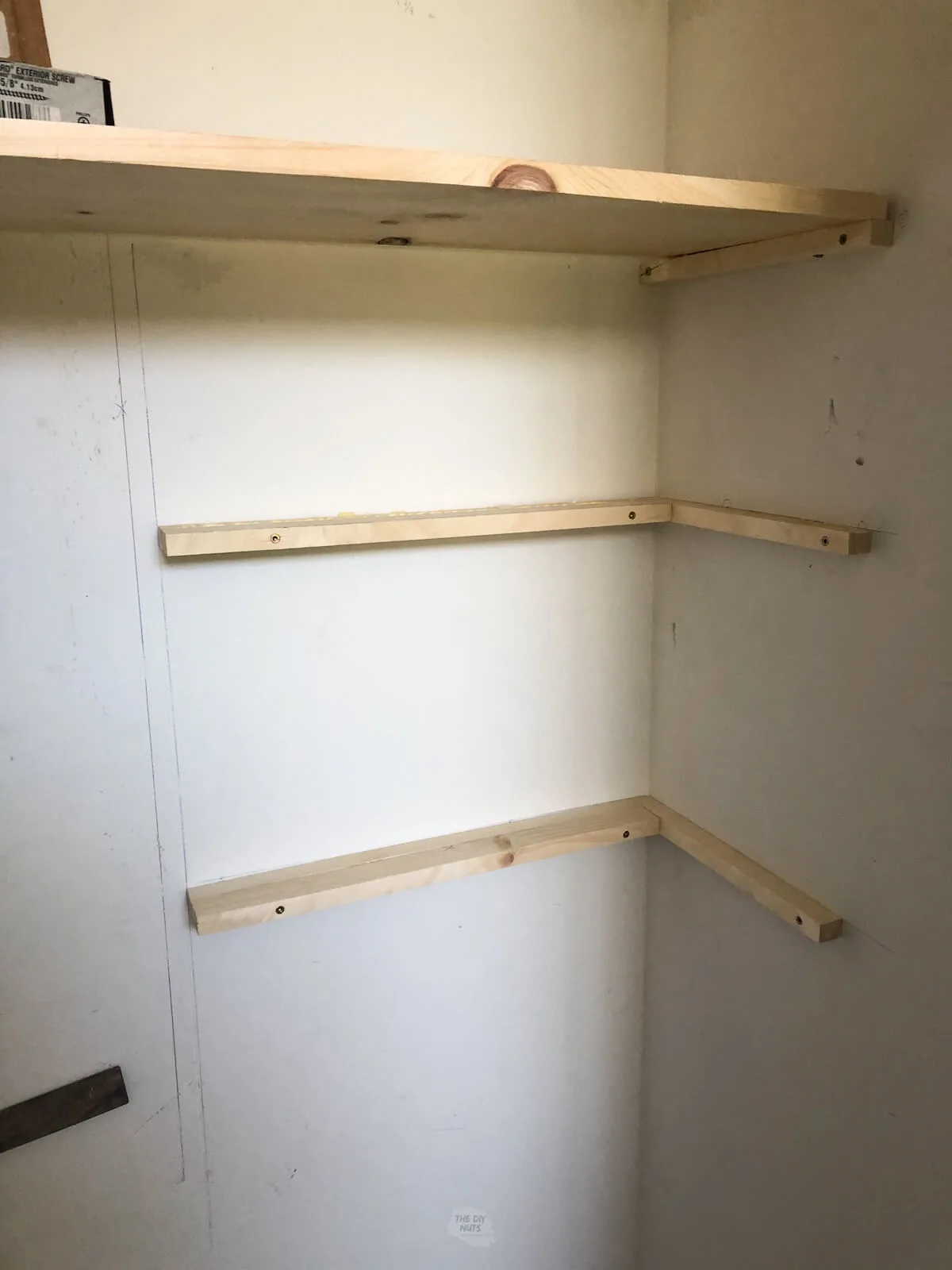 adding more pine wood brackets for wood closet shelves under two larger shelves.